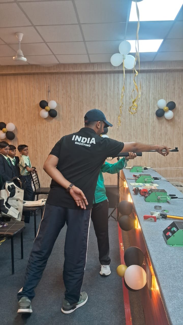 A coach demonstrating the pistol stance to a student while other students watch