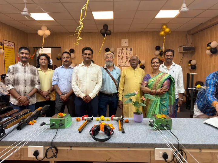 Guests standing together behind a table of air rifles, tools and flowers at the academy